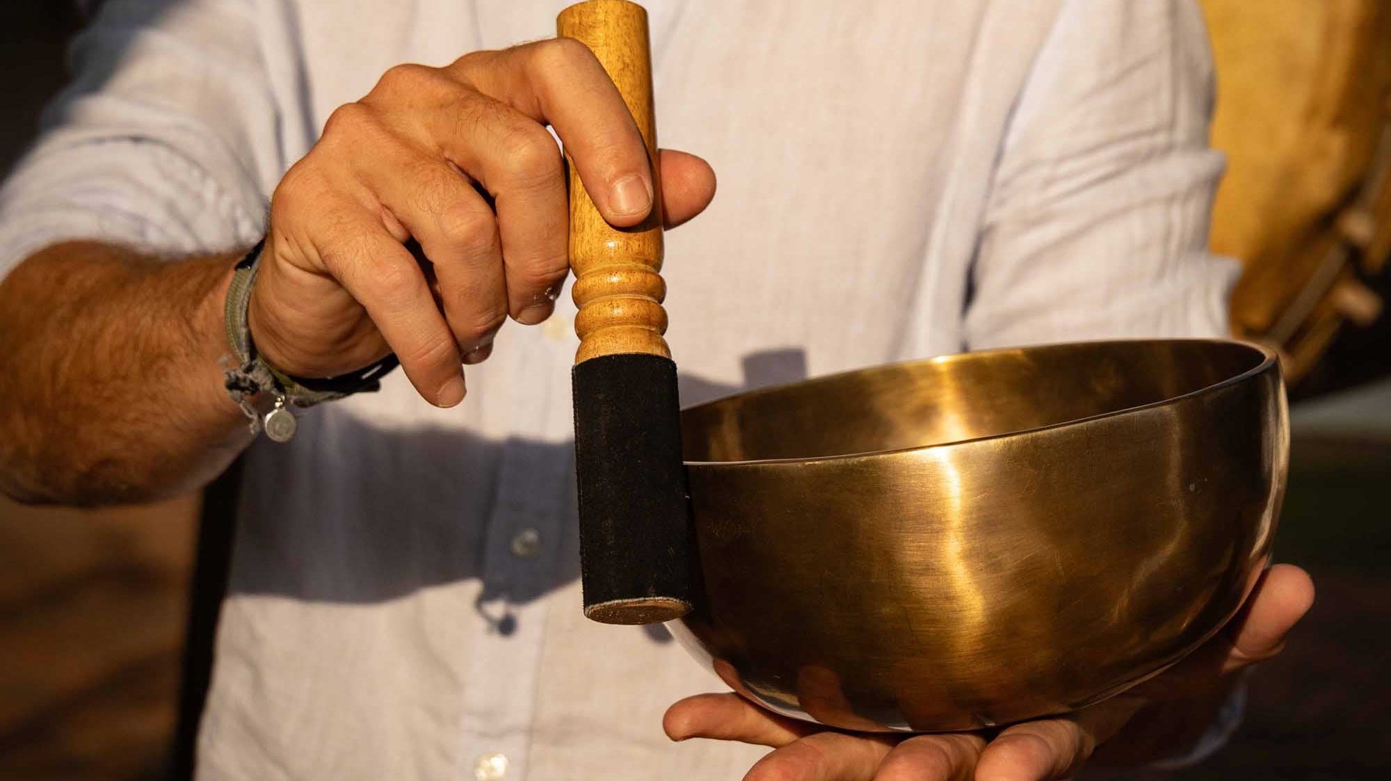 Using a Tibetan singing bowl with a wooden mallet