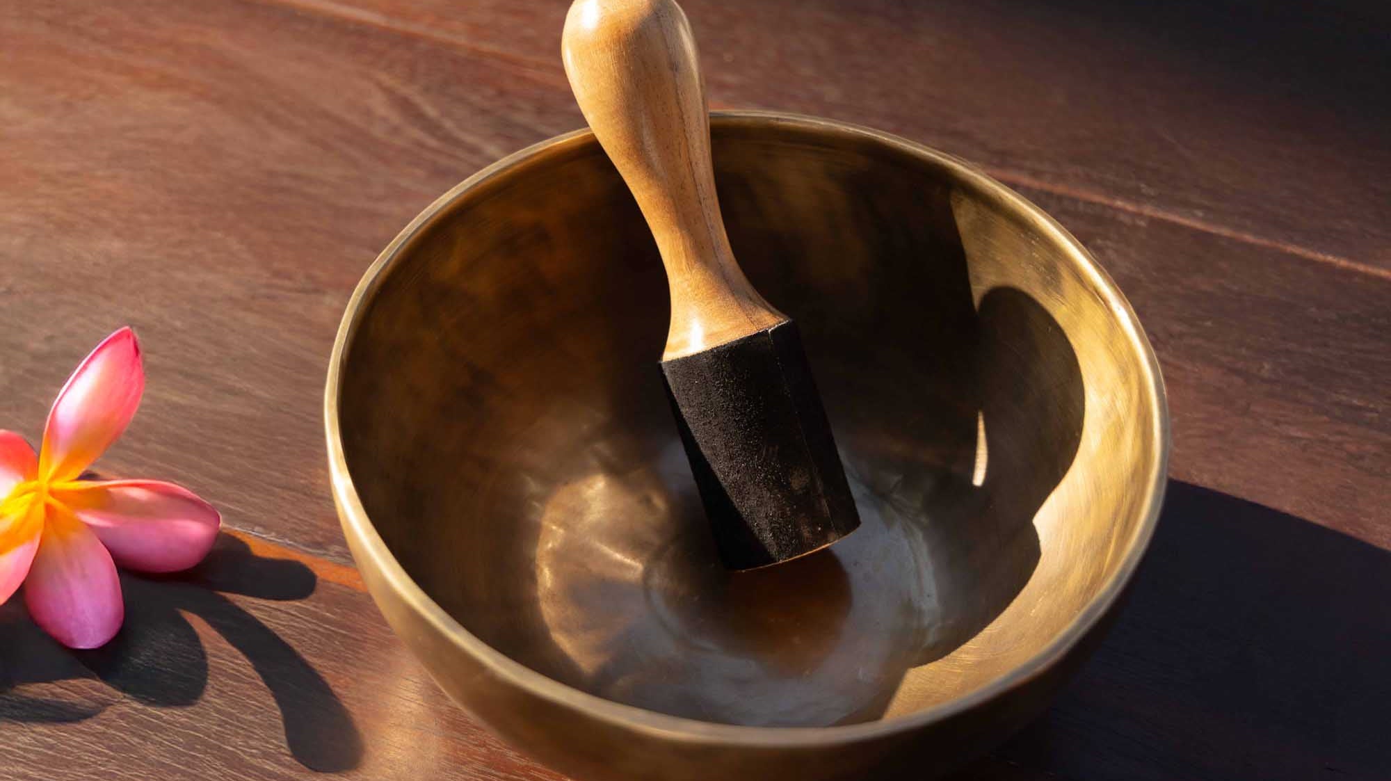 Bronze Tibetan singing bowl in a calm interior, illustrating how sustained resonance, harmonic layers and natural decay can help the listener slow down.