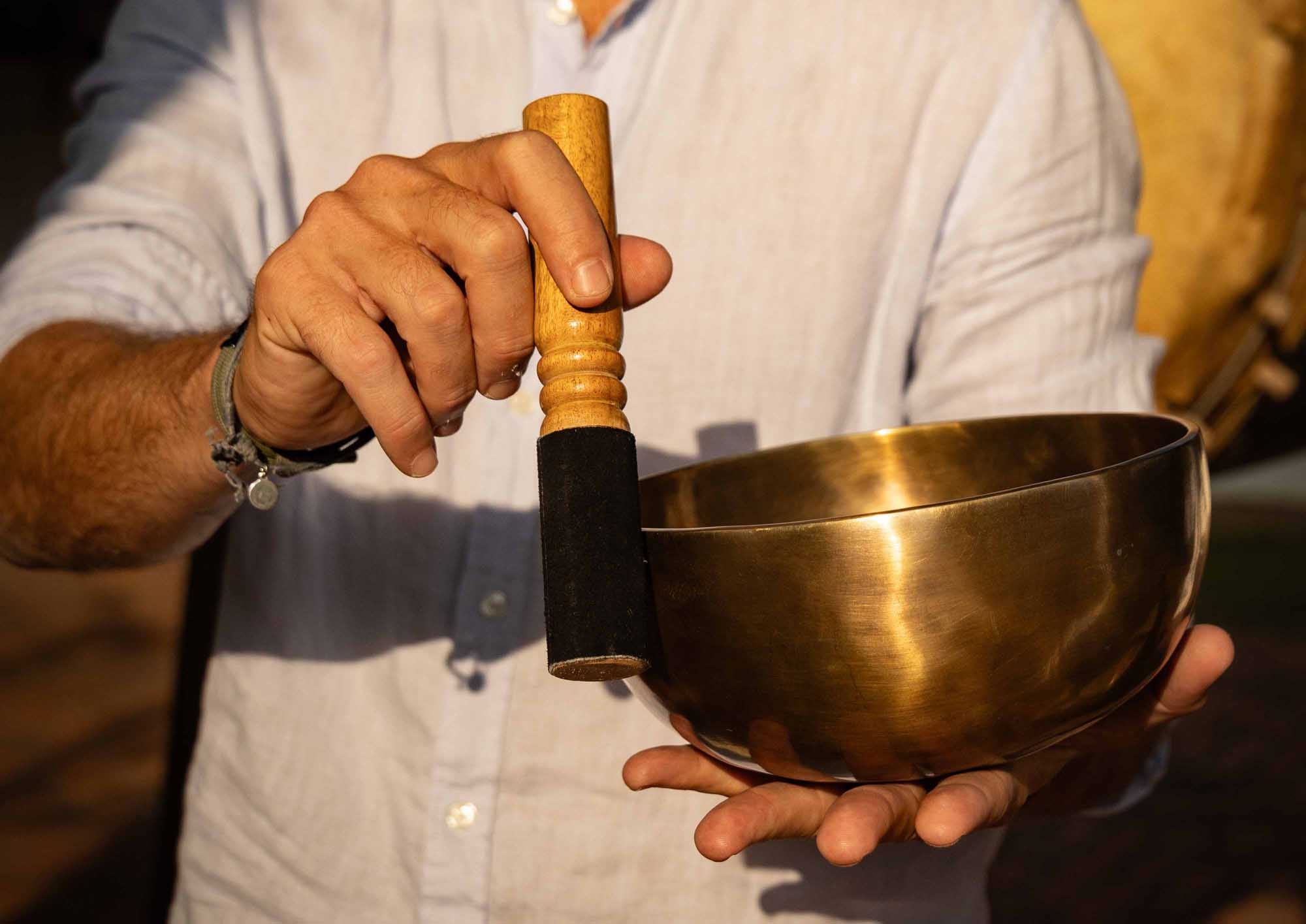 Using a Tibetan singing bowl with a wooden mallet