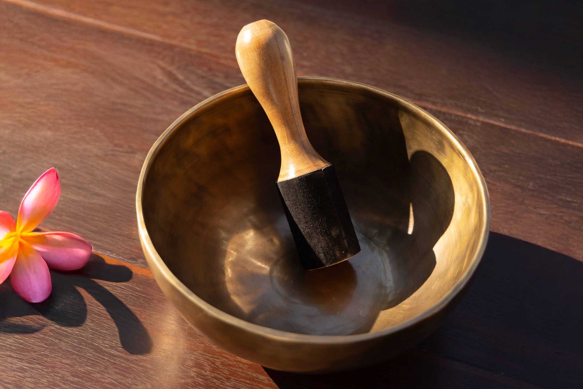 Bronze Tibetan singing bowl in a calm interior, illustrating how sustained resonance, harmonic layers and natural decay can help the listener slow down.